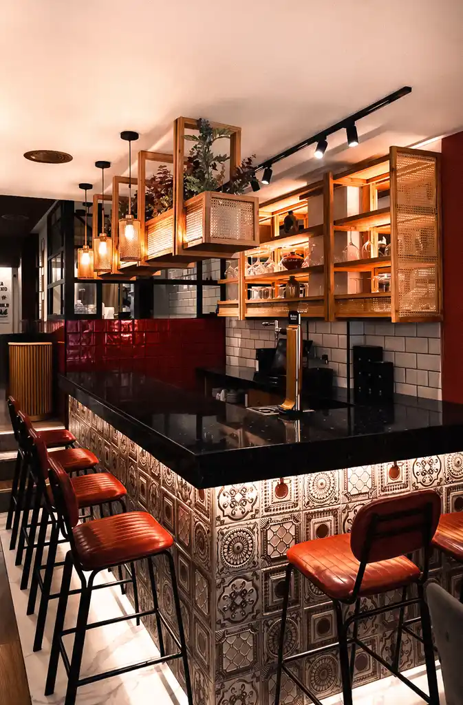 La barra de AltaCalle, con sus taburetes y estanterías de madera