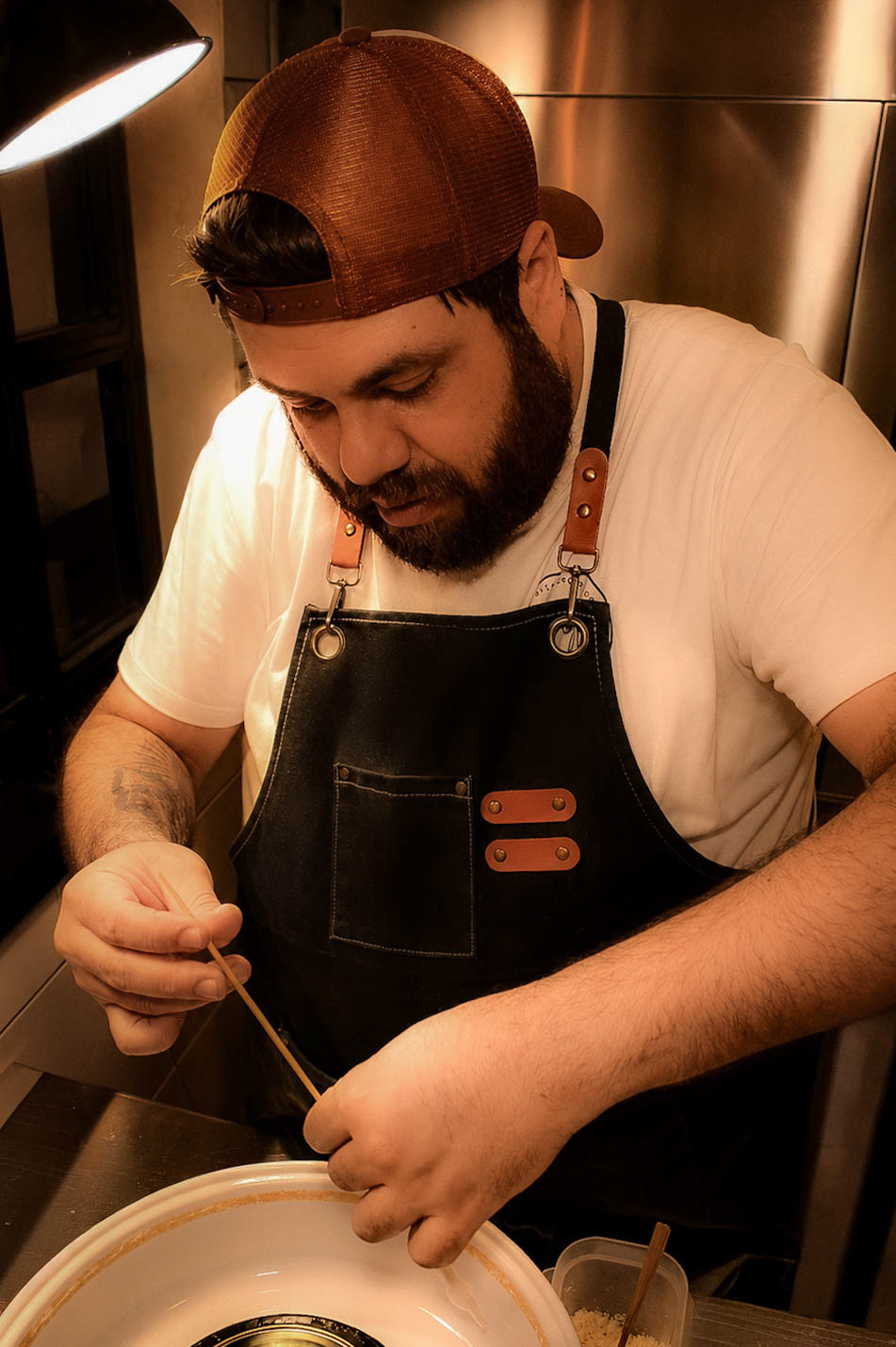 Chef de AltaCalle concentrado preparando un plato