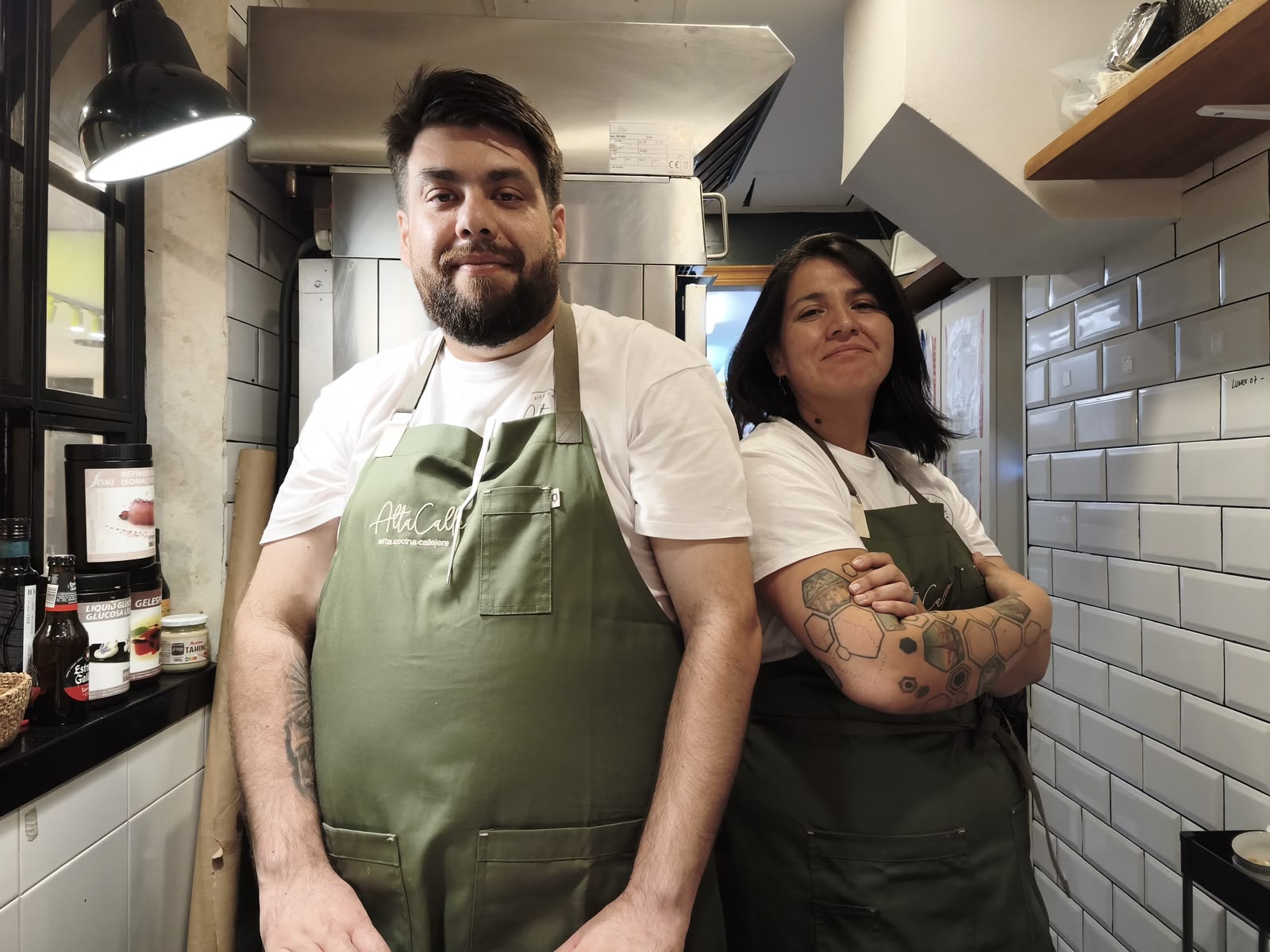 Dos cocineros del equipo con delantal de AltaCalle en la cocina