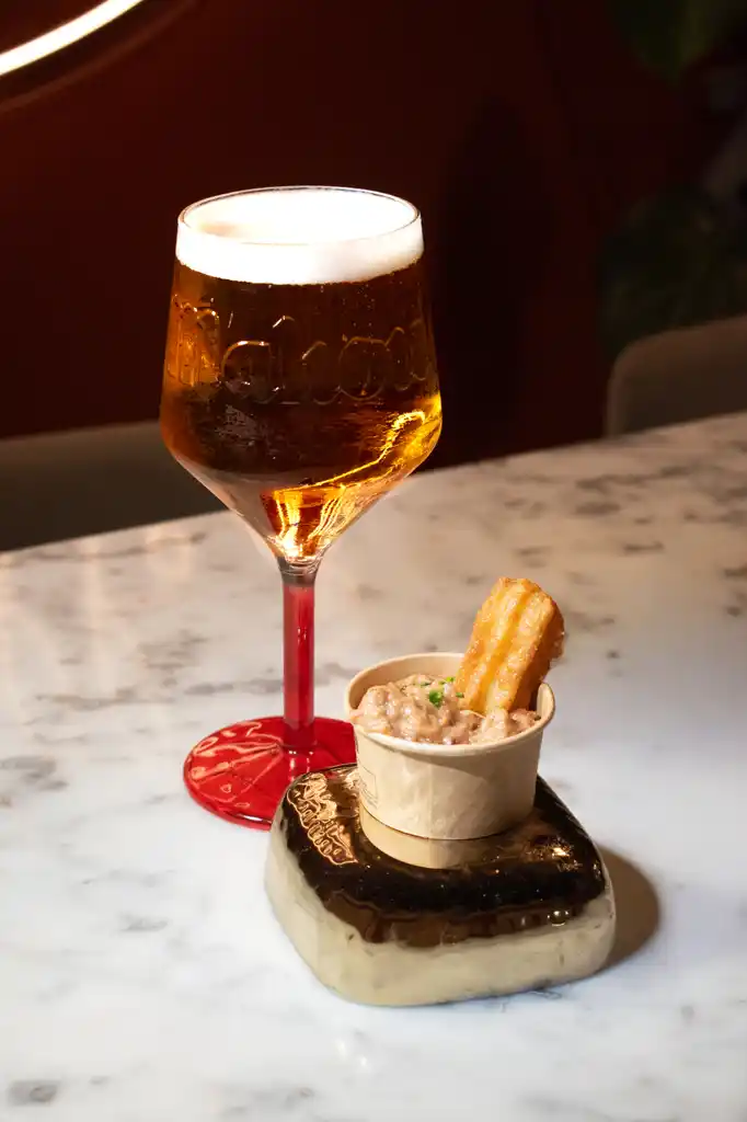 Una caña y un aperitivo de la casa sobre la mesa de AltaCalle